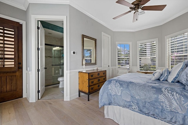 bedroom featuring ceiling fan, light wood-type flooring, ornamental molding, and connected bathroom