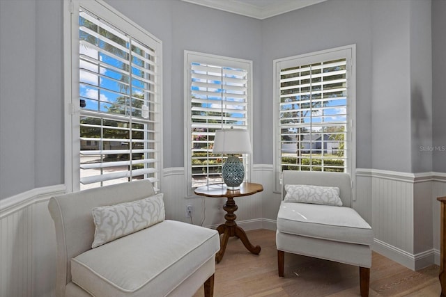 living area featuring hardwood / wood-style flooring and ornamental molding