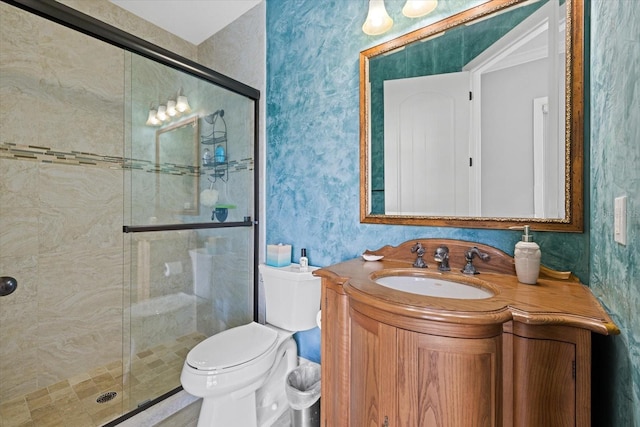 bathroom featuring vanity, toilet, and a shower with shower door