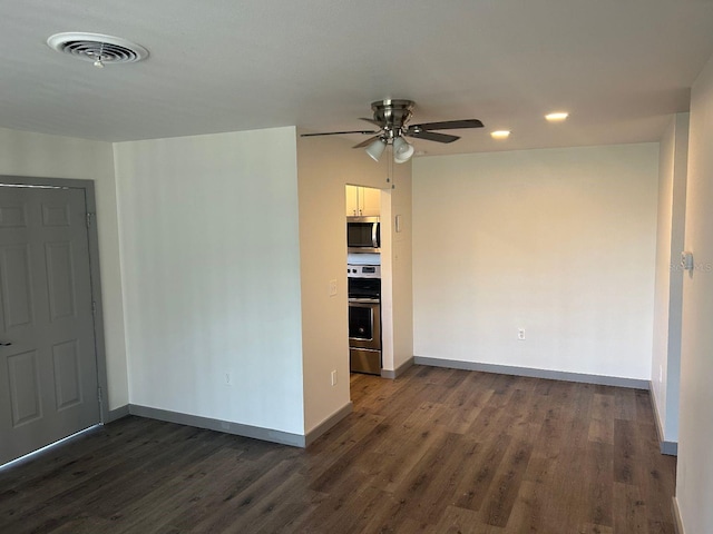 empty room with ceiling fan and dark hardwood / wood-style floors