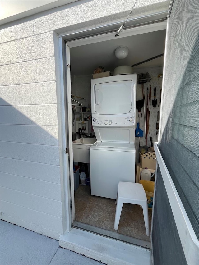 clothes washing area featuring stacked washer and clothes dryer