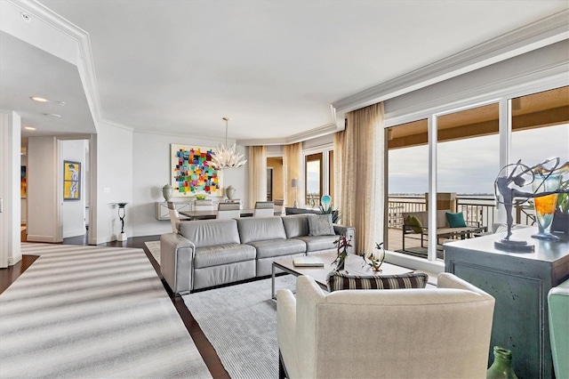 living room featuring hardwood / wood-style flooring, crown molding, and a notable chandelier