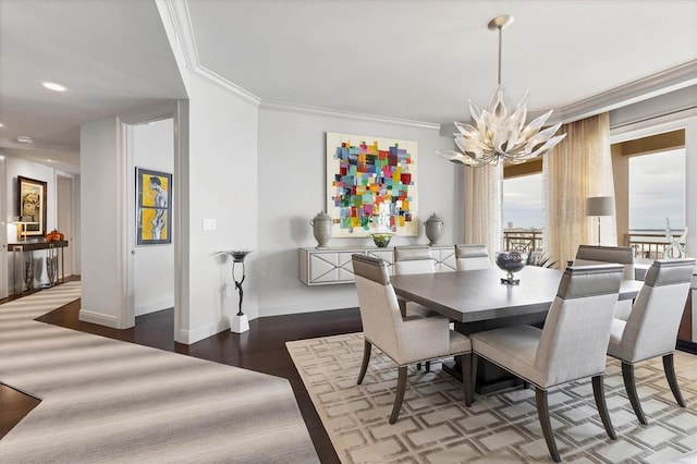 dining room featuring dark hardwood / wood-style flooring, crown molding, and a notable chandelier