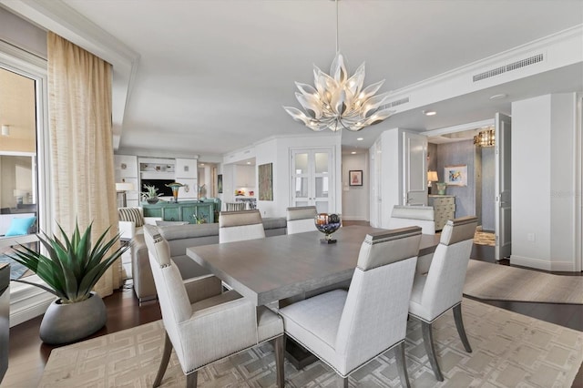 dining area featuring a chandelier, hardwood / wood-style flooring, and ornamental molding