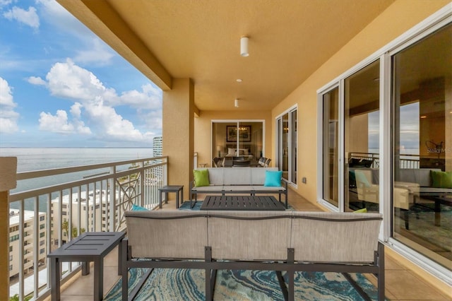 balcony with an outdoor living space and a water view