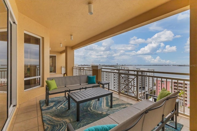 balcony with outdoor lounge area and a water view