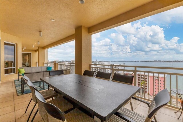 view of patio with outdoor lounge area, a water view, and a balcony