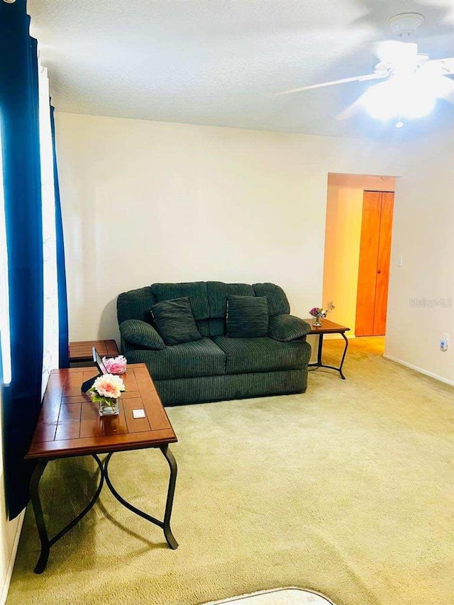 carpeted living room featuring ceiling fan