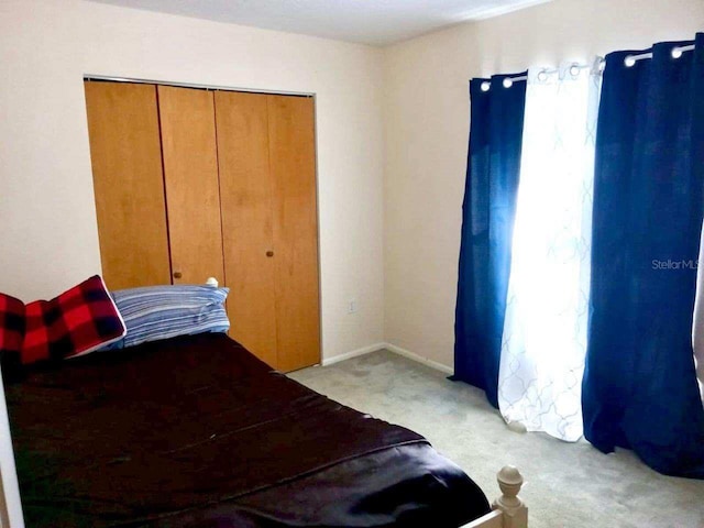 bedroom with a closet and light colored carpet