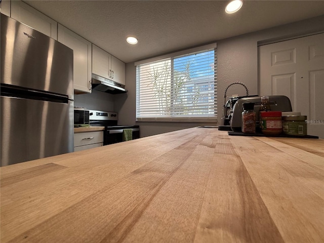 kitchen with white cabinetry, a textured ceiling, and appliances with stainless steel finishes