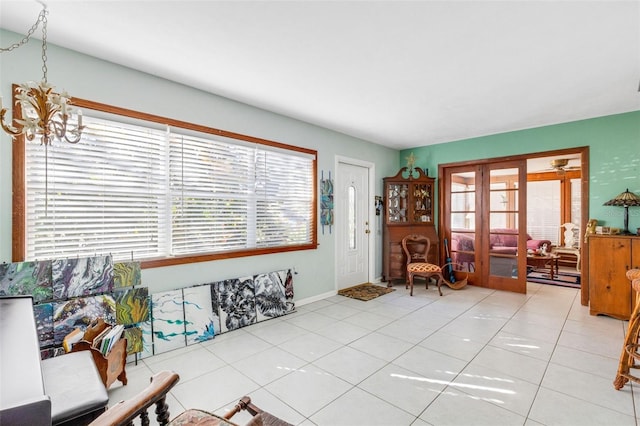 interior space featuring french doors, an inviting chandelier, and light tile patterned floors