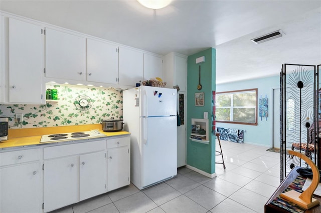 kitchen featuring light tile patterned floors, white appliances, and white cabinets