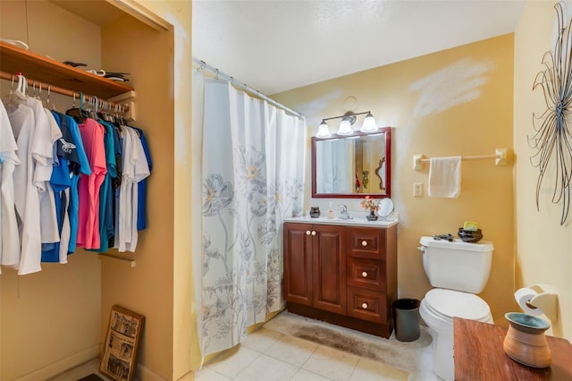 bathroom with curtained shower, toilet, vanity, and tile patterned flooring