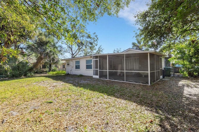 back of house with a yard and a sunroom