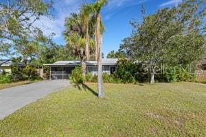 view of front of property with a carport, driveway, and a front yard