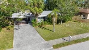 view of front facade featuring a front yard, a carport, and driveway