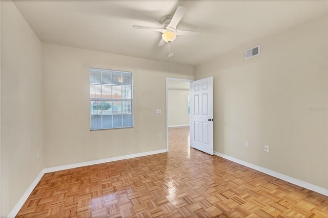 unfurnished room with ceiling fan and light parquet flooring