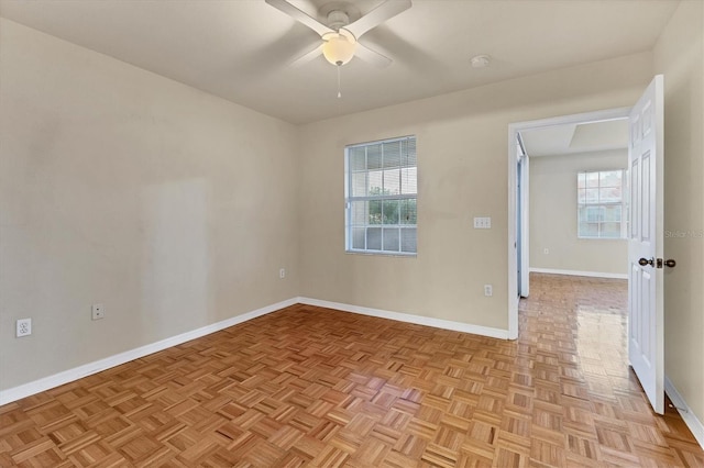 empty room with light parquet floors and ceiling fan