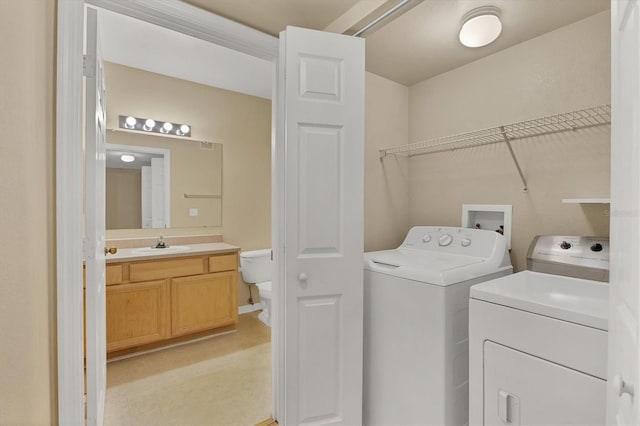 washroom with washer and clothes dryer and sink