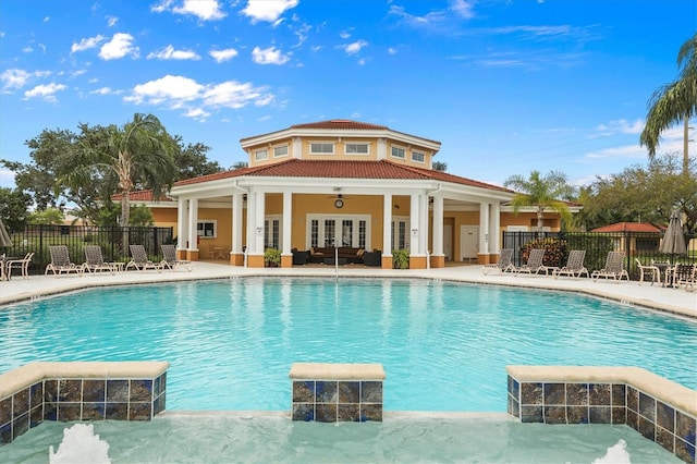 view of swimming pool with a patio area, pool water feature, and french doors