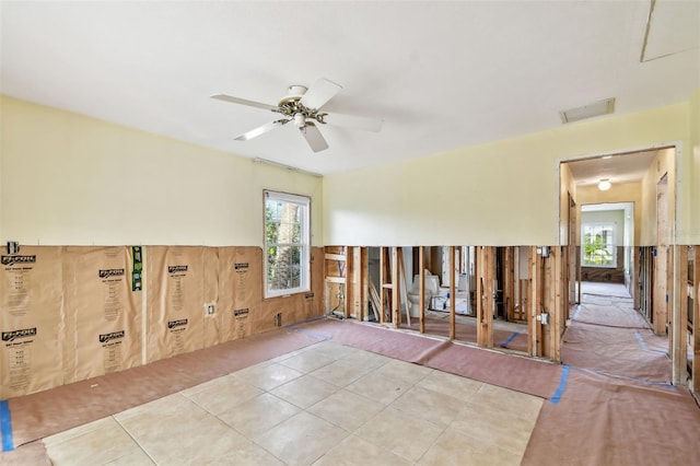 tiled spare room featuring ceiling fan