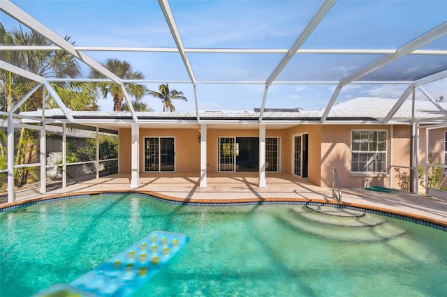 view of swimming pool with glass enclosure and a patio area