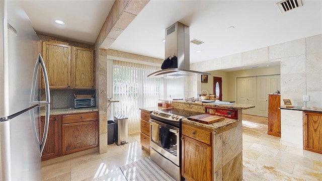 kitchen with island exhaust hood, backsplash, stainless steel appliances, and an island with sink