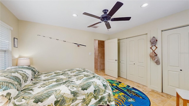 tiled bedroom featuring ceiling fan and multiple closets