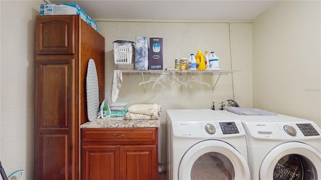 washroom with cabinets and washer and dryer