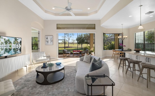 tiled living room featuring a tray ceiling, crown molding, plenty of natural light, and ceiling fan with notable chandelier