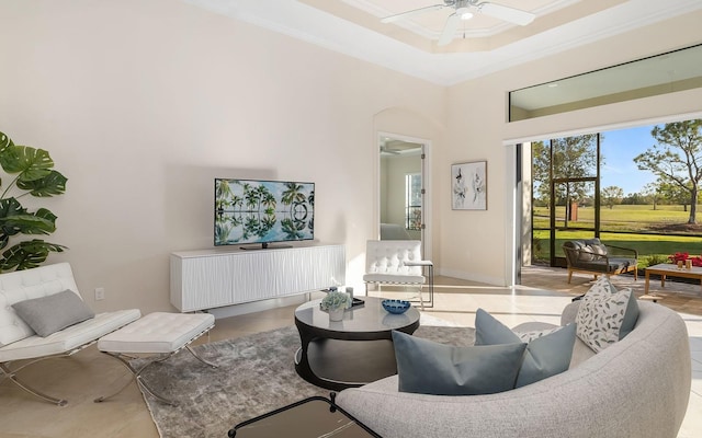 tiled living room with ceiling fan and crown molding