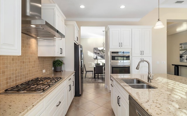 kitchen featuring white cabinetry, light stone counters, stainless steel appliances, and wall chimney range hood