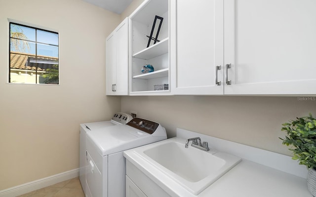 laundry room featuring cabinets, separate washer and dryer, light tile patterned flooring, and sink