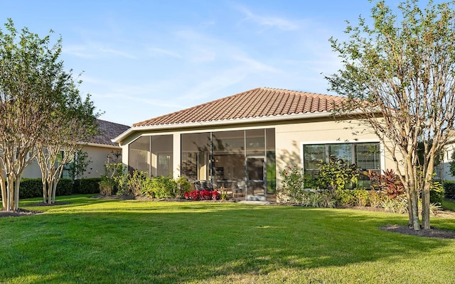 rear view of house with a sunroom and a yard