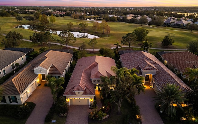 aerial view at dusk featuring a water view