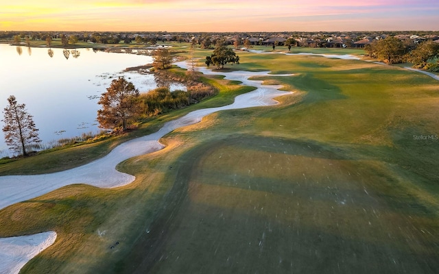 aerial view at dusk featuring a water view