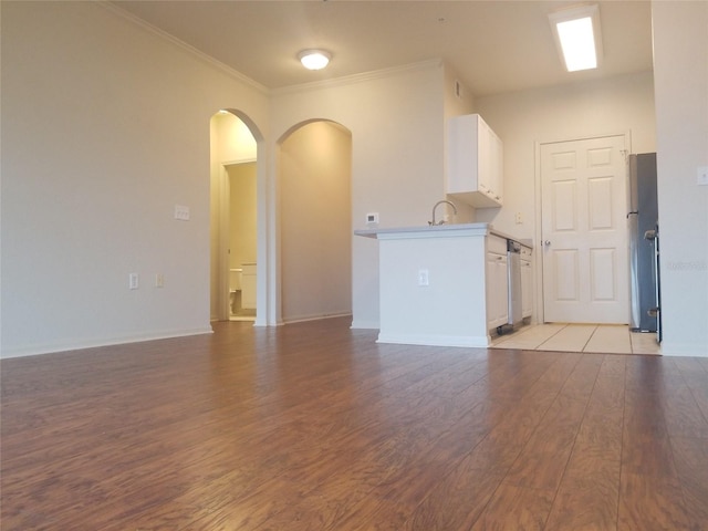 unfurnished living room featuring light wood-type flooring, crown molding, and sink