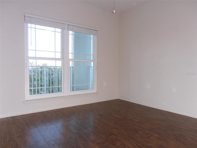 unfurnished room featuring a healthy amount of sunlight and dark wood-type flooring