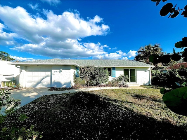 single story home featuring a front lawn and a garage