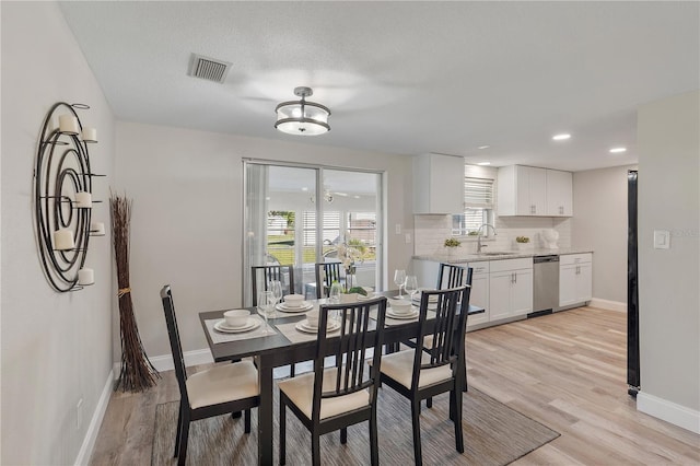 dining room with a textured ceiling, light hardwood / wood-style floors, and sink