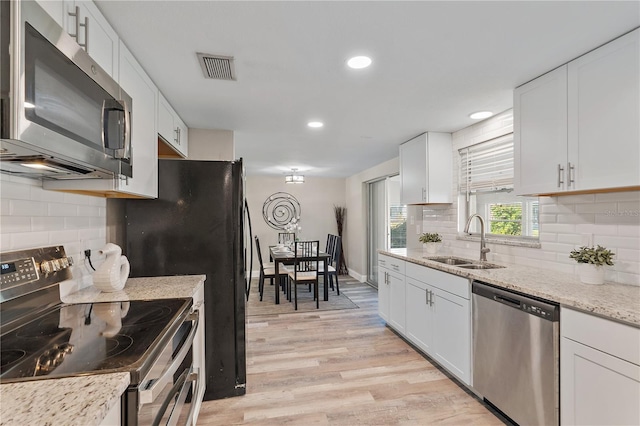 kitchen featuring white cabinets, light hardwood / wood-style floors, sink, and stainless steel appliances