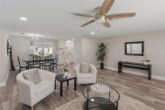 living room with ceiling fan and light wood-type flooring