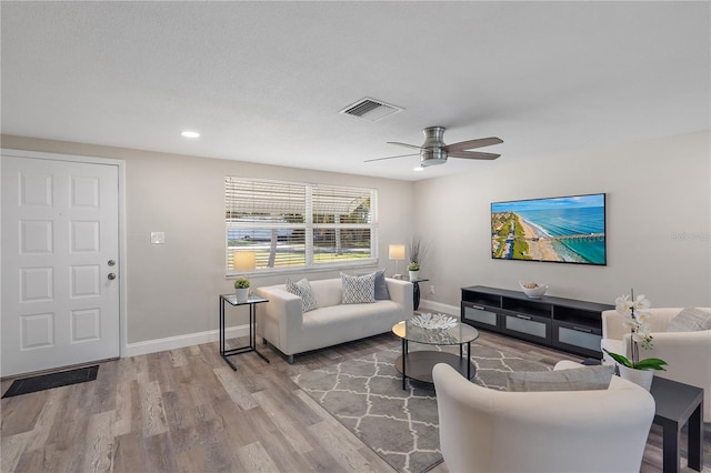 living room with wood-type flooring and ceiling fan