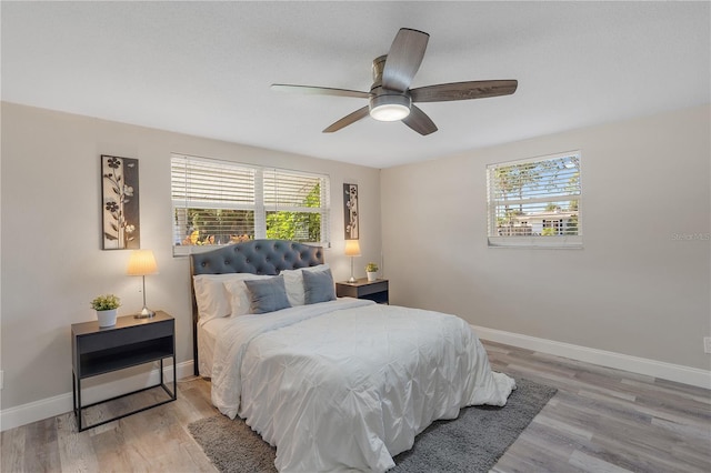 bedroom with multiple windows, ceiling fan, and light wood-type flooring