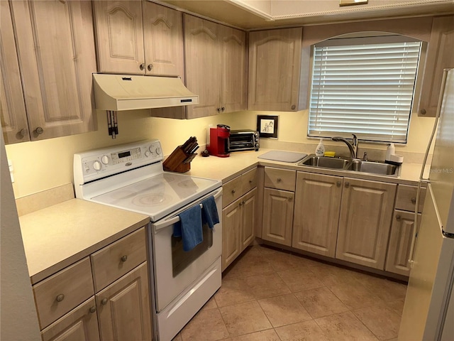 kitchen with light tile patterned floors, white appliances, sink, and light brown cabinetry