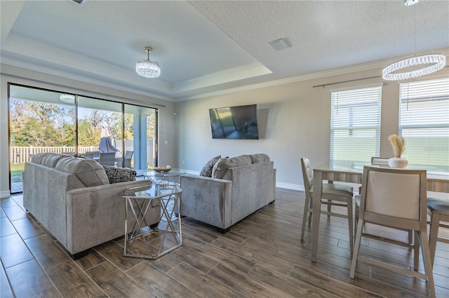 living room with dark hardwood / wood-style flooring, a healthy amount of sunlight, and a textured ceiling