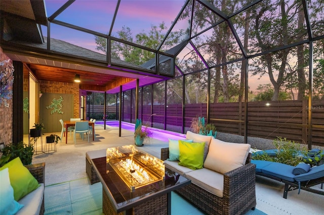 patio terrace at dusk featuring an outdoor living space with a fire pit and a lanai