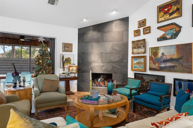 living room with ceiling fan, lofted ceiling, and a premium fireplace