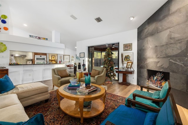 living room featuring vaulted ceiling and light hardwood / wood-style flooring