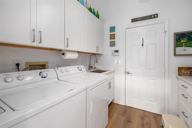 laundry area with washer and dryer, light hardwood / wood-style flooring, cabinets, and sink